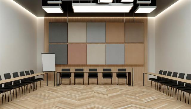 Modern conference room with black chairs, wooden tables, a flip chart, and colorful acoustic panels on the wall.