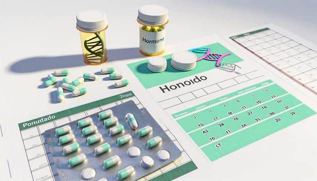 Pills, pill bottles, a DNA model, and calendars on a table.