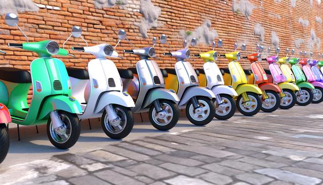 A row of colorful retro scooters parked against a red brick wall.