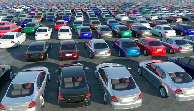 A large parking lot filled with rows of colorful cars.