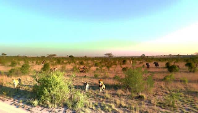 A savanna landscape with lions, giraffes, elephants, and antelopes amidst scattered trees and grass.