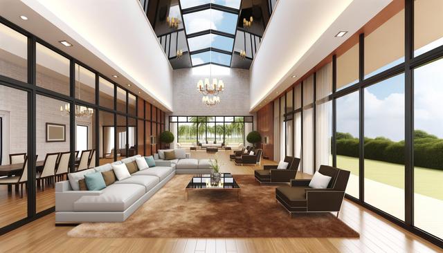 Spacious modern living room with glass walls, skylight, beige sofas, and brown armchairs.