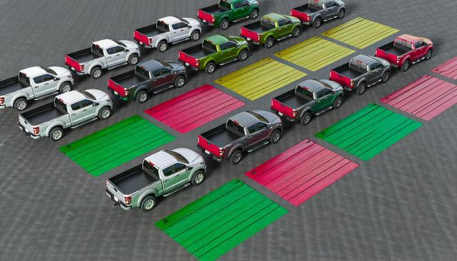 Rows of parked pickup trucks with colorful rectangular patterns on the ground.