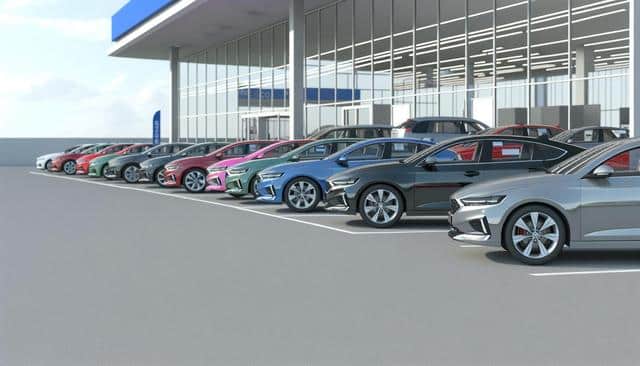 Multiple colorful cars parked in a row outside a dealership with large glass windows.