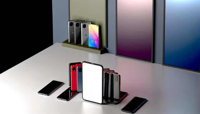 Several smartphones with colorful screens and back covers displayed on a table and stand.