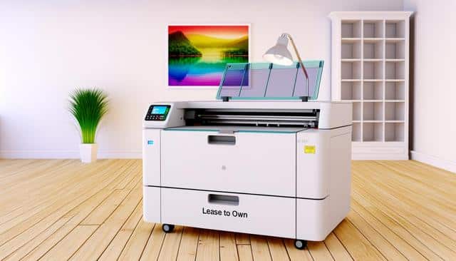 A large printer on wheels in a bright room with wood floors, a potted plant, a colorful landscape picture, and an empty bookcase.