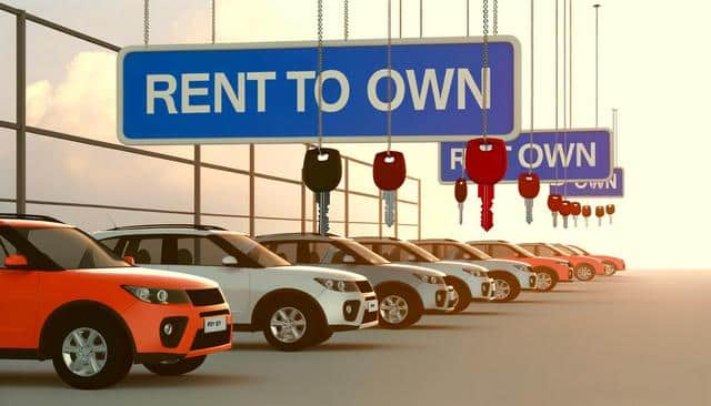 Cars lined up under "Rent to Own" signs with hanging keys.