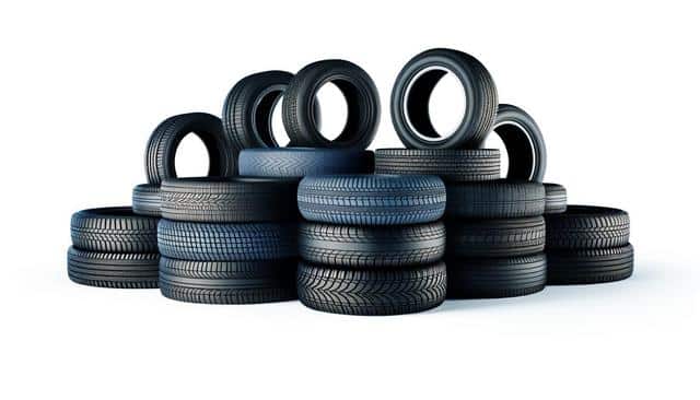 A pile of black rubber tires stacked together.