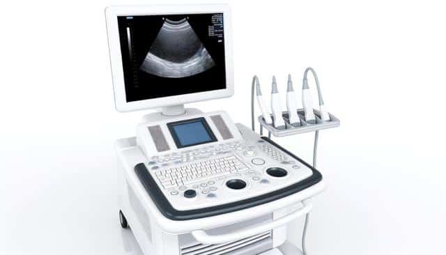 Ultrasound machine with screen, keyboard, and four probes on a stand.