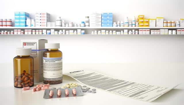 Pharmacy scene with medicine bottles, blister packs, and a prescription paper on a counter; shelves with various medications are in the background.