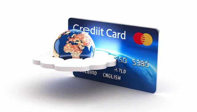 A blue credit card with a globe and a cloud symbol in front.