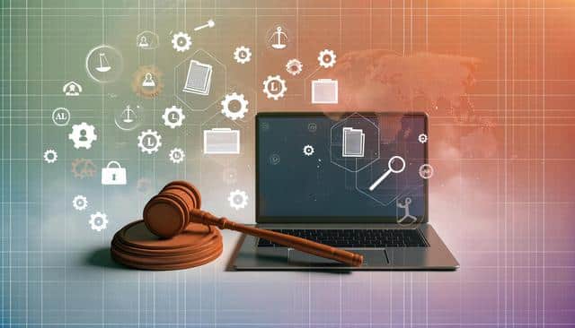 A gavel and laptop with legal icons and gears on a digital world map backdrop.