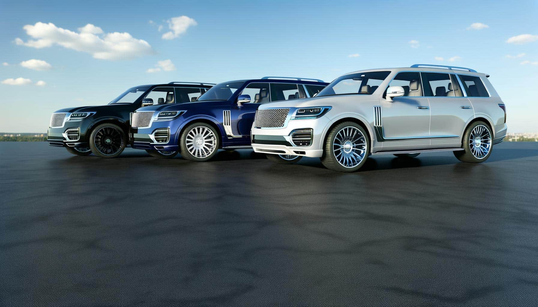 Three luxury SUVs in black, blue, and silver, parked on a concrete surface under a clear sky.