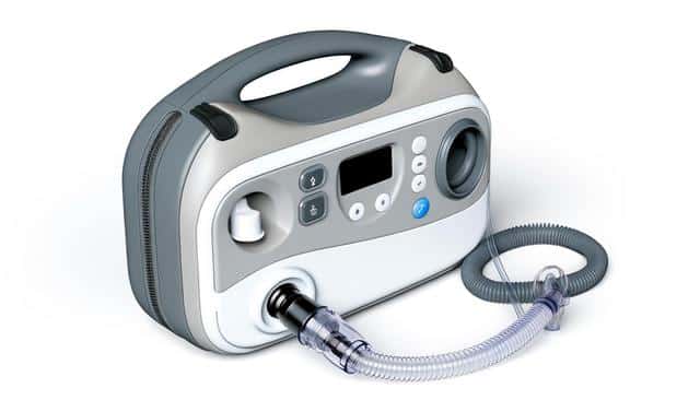 A portable oxygen concentrator with a handle, control panel, and attached tubing.